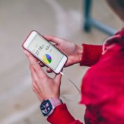 Nahaufnahme zweier Frauenhände die ein Smartphone halten. Darauf sieht man eine Fitnessapp mit einem bunten Kreisdiagramm und Angaben zu verbrannten Kalorien und gerannten Kilometern.  Nahaufnahme zweier Frauenhände die ein Smartphone halten. Darauf sieht man eine Fitnessapp mit einem bunten Kreisdiagramm und Angaben zu verbrannten Kalorien und gerannten Kilometern.